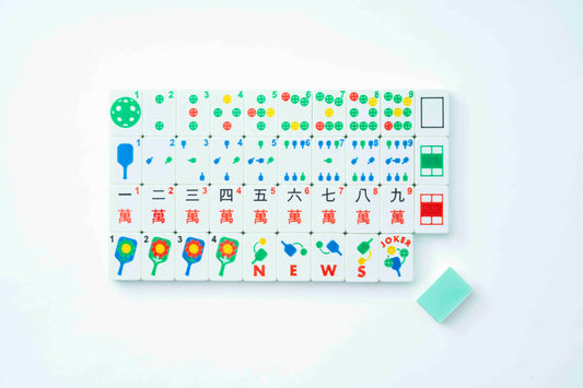 A set of Pickleball theme Mahjong-style tiles arranged in a grid on a white background, with a small mint green eraser placed to the lower right. The tiles feature colorful symbols, Chinese characters, numbers, and pips on a white base.