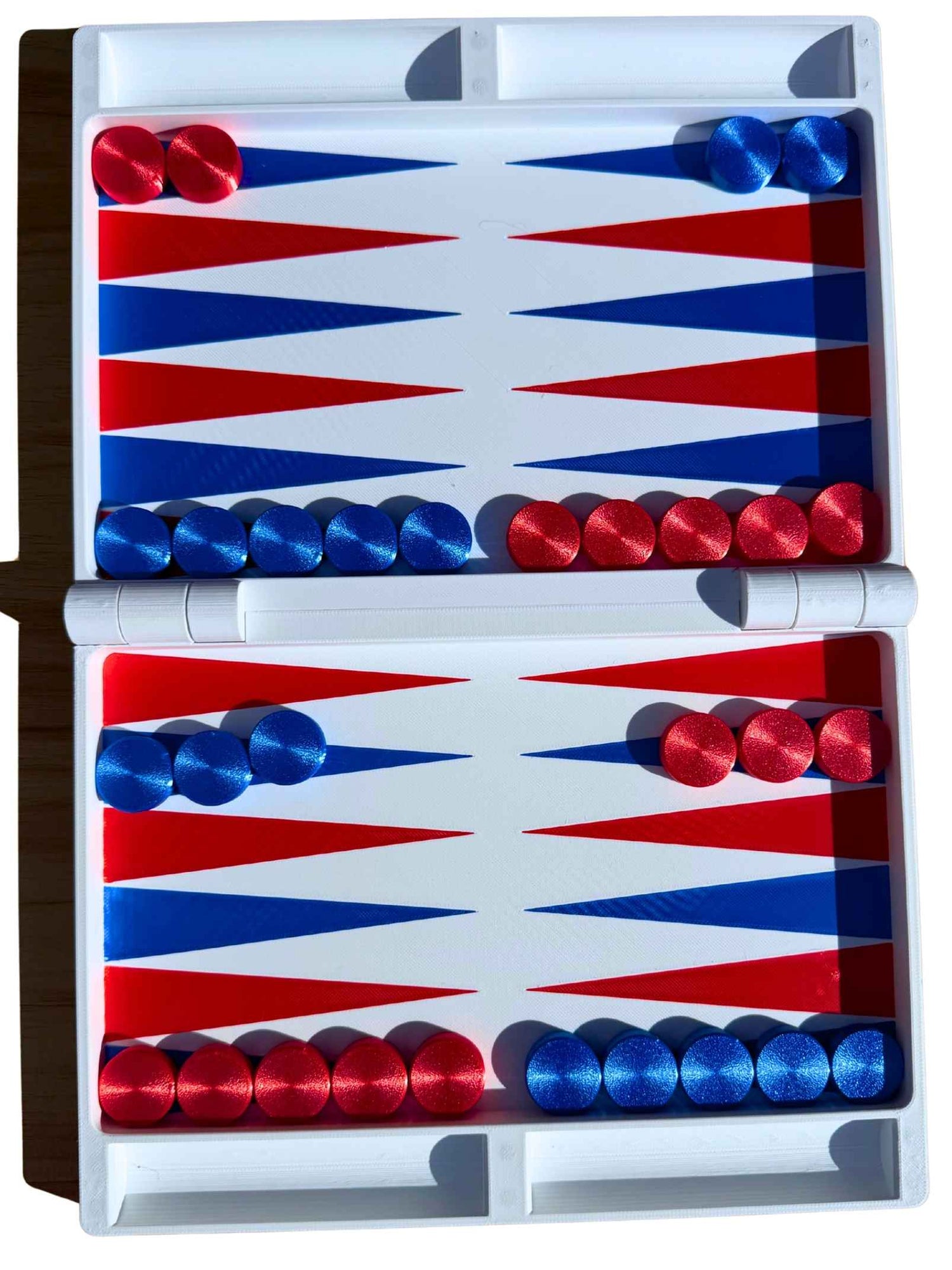 Open white travel backgammon board with red and blue triangle points and checkers set up for the start of a game, viewed from above