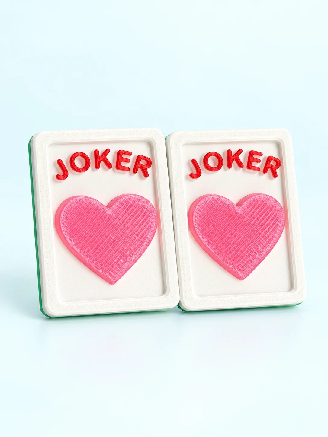 Front view of two heart joker mahjong tiles with a pink heart and green backs, by Spools