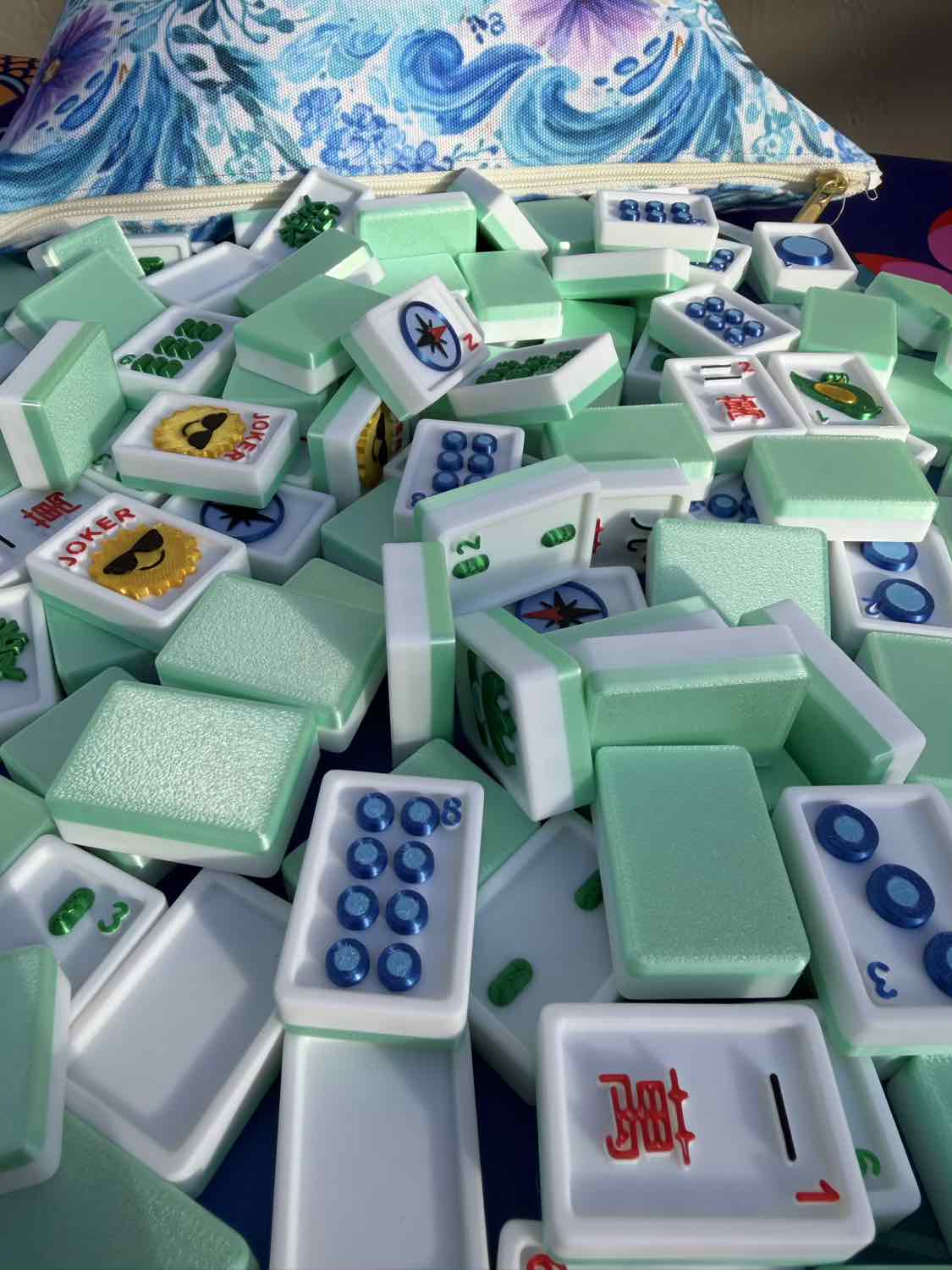 Stack of green and white麻将 tiles with various symbols on a colorful mahjong background