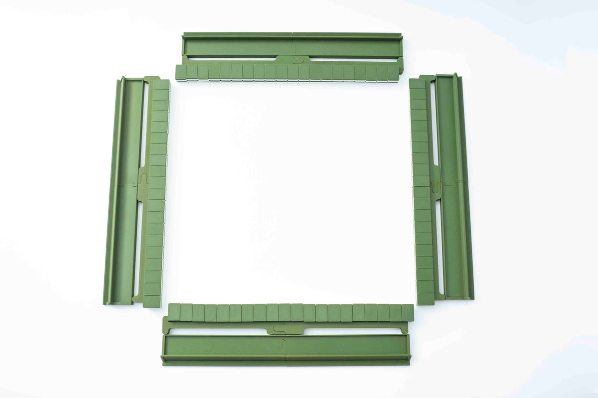 Four olive green plastic mahjong pieces arranged in a square frame on a white background.