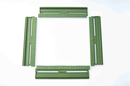 Four olive green plastic mahjong pieces arranged in a square frame on a white background.
