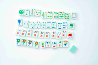 A set of white mahjong tiles arranged in rows on a clean white background, with a small light green tile placed beside them.