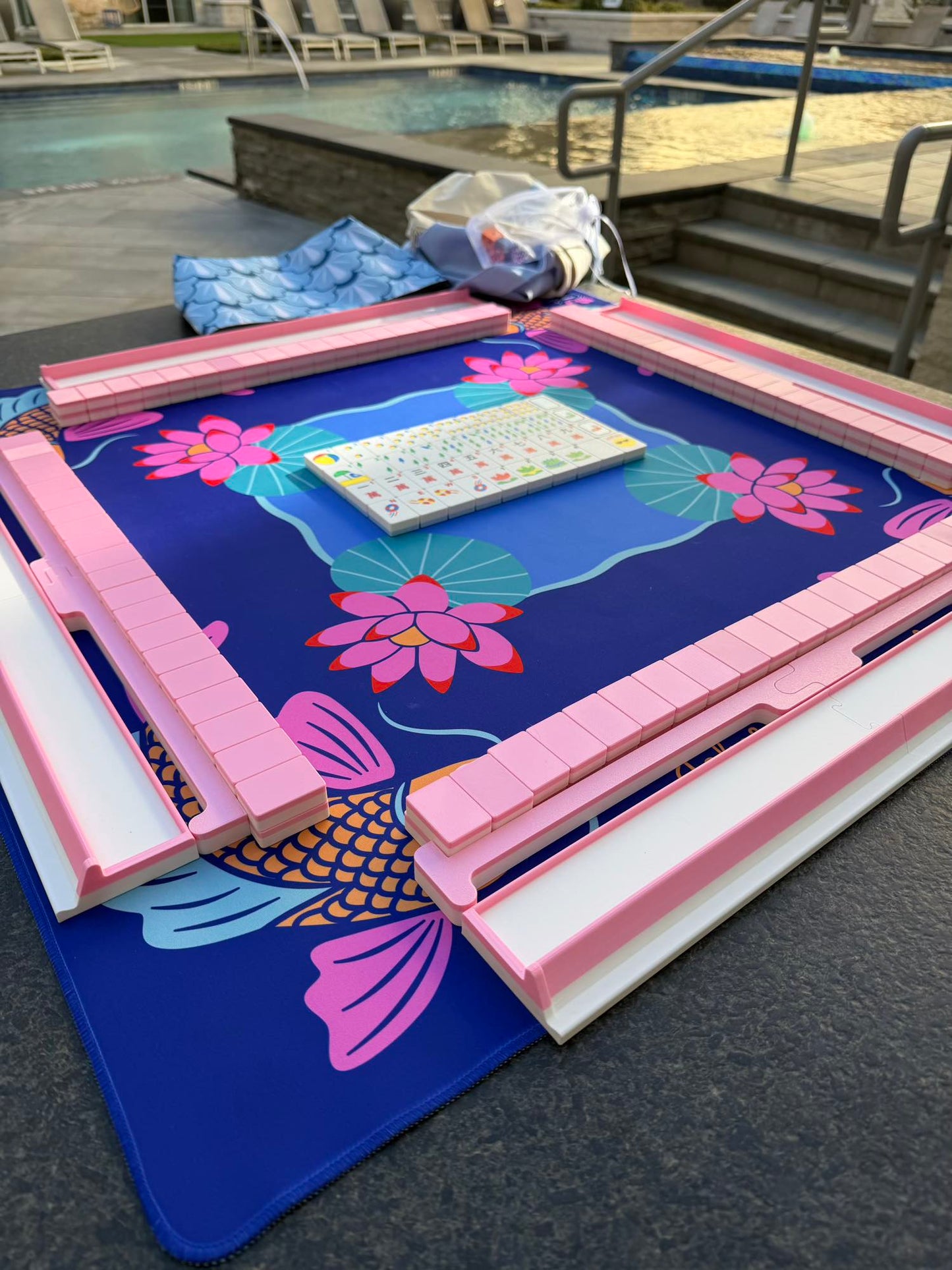 Spools Pink Compass mahjong tiles arranged on a compass-themed playing mat with pink racks.
