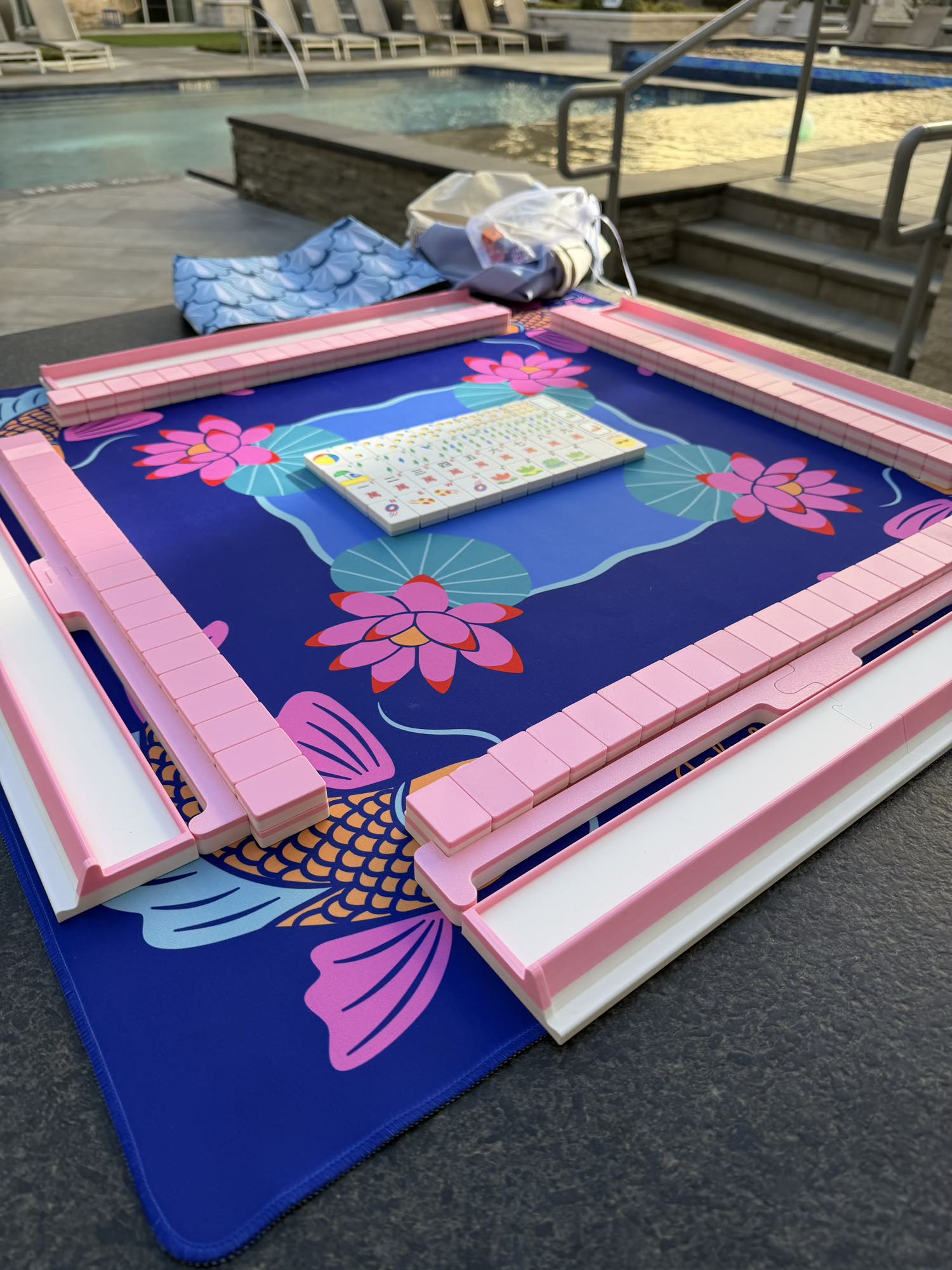 Spools Pink Compass mahjong tiles arranged on a compass-themed playing mat with pink racks.
