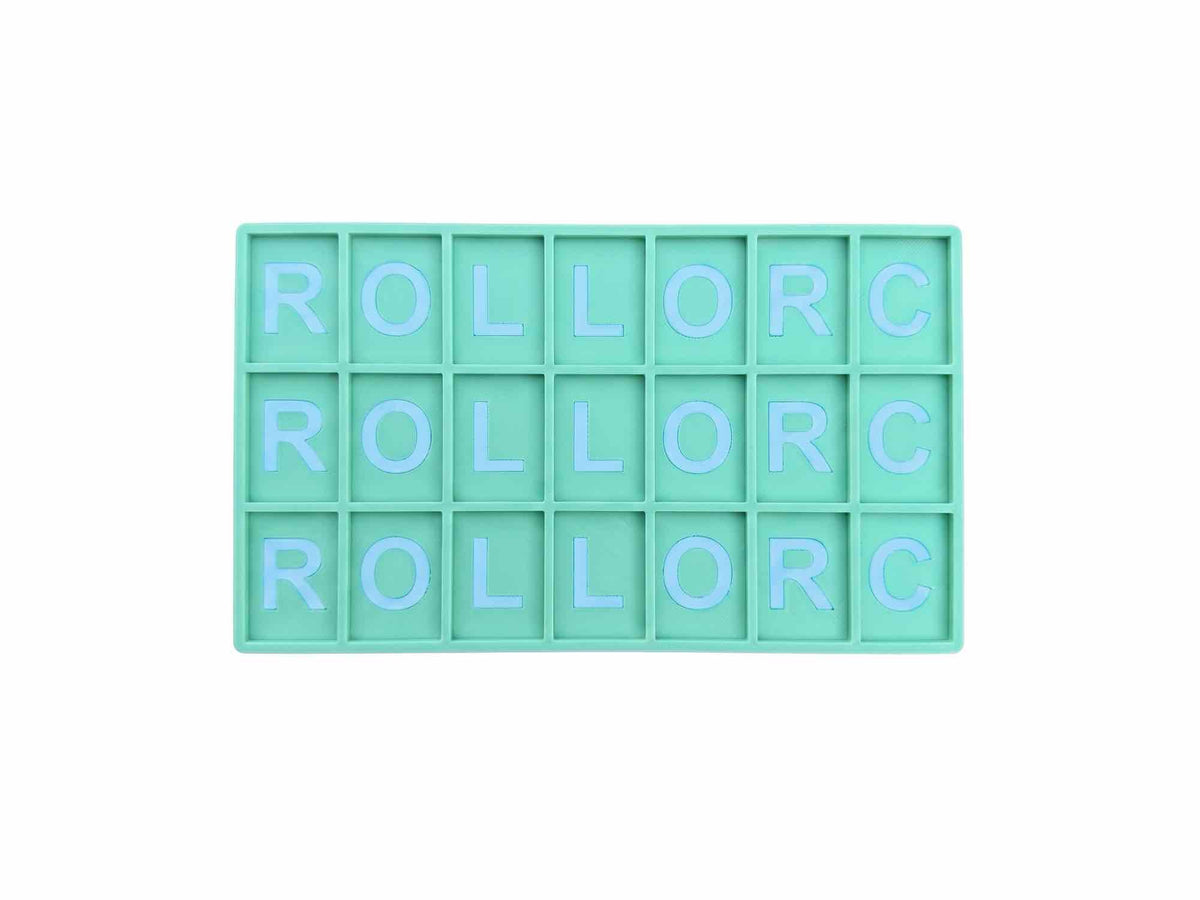 A mint green rectangular grid tray with 15 square compartments, each containing the letters 'ROLL' and 'C' in light blue, arranged to spell 'ROLL OR C' across three rows, isolated on a white background.