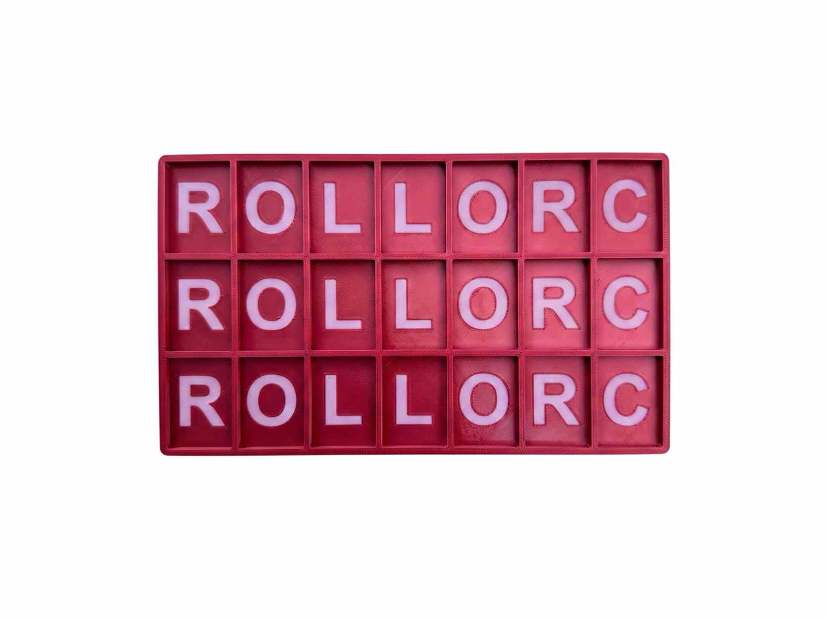 A rectangular red plastic alphabet block board with 20 individual letter compartments, each filled with a pink letter, spelling out 'ROLLORC' vertically three times, isolated on a white background.