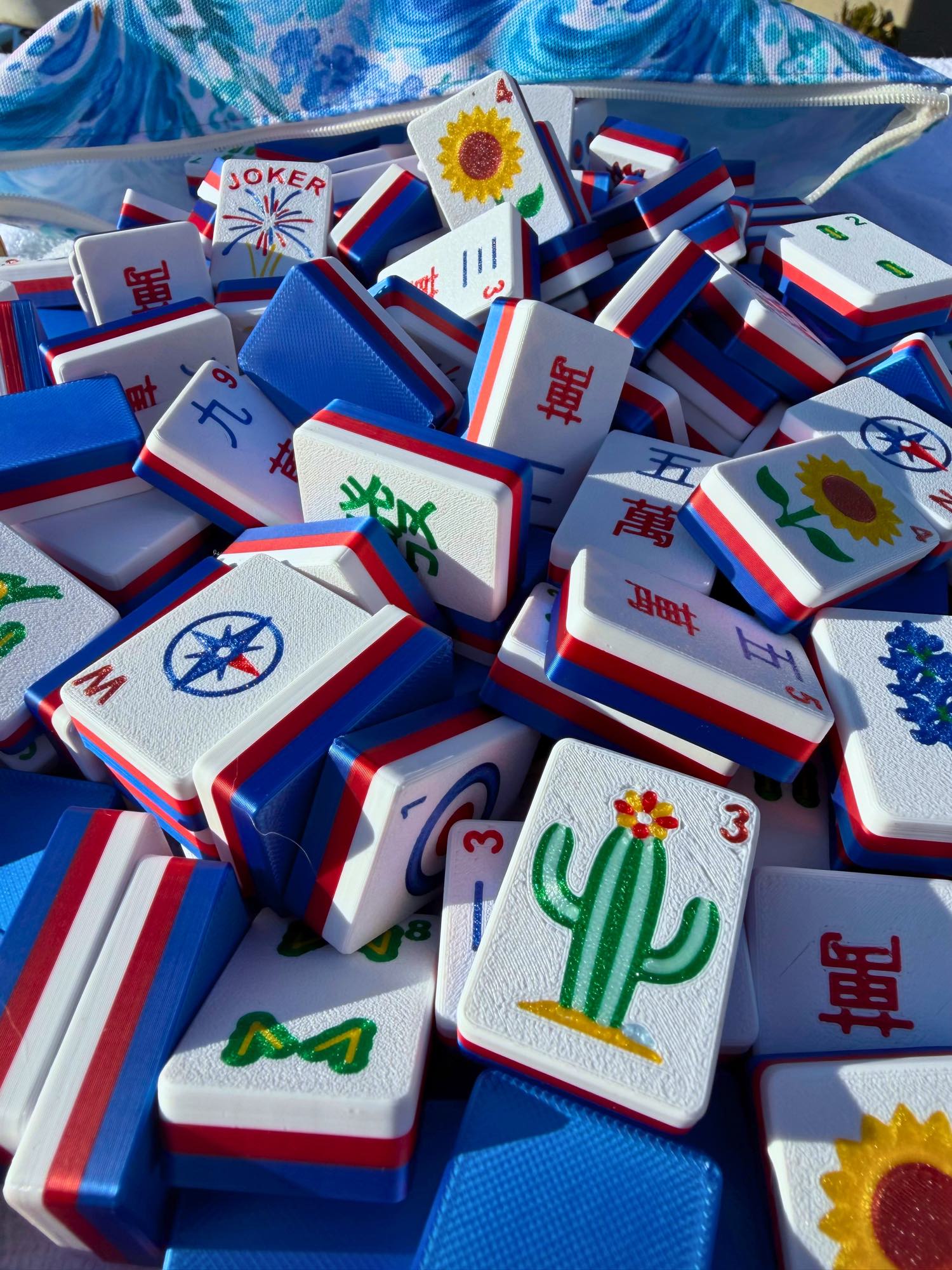 Stack of colorful Mahjong tiles with various symbols on a blue and white checkered background.