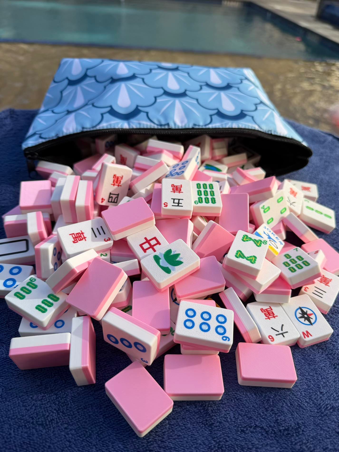 Spools Pink Compass lightweight mahjong tiles poured from a carrying bag, designed for easy travel and setup.