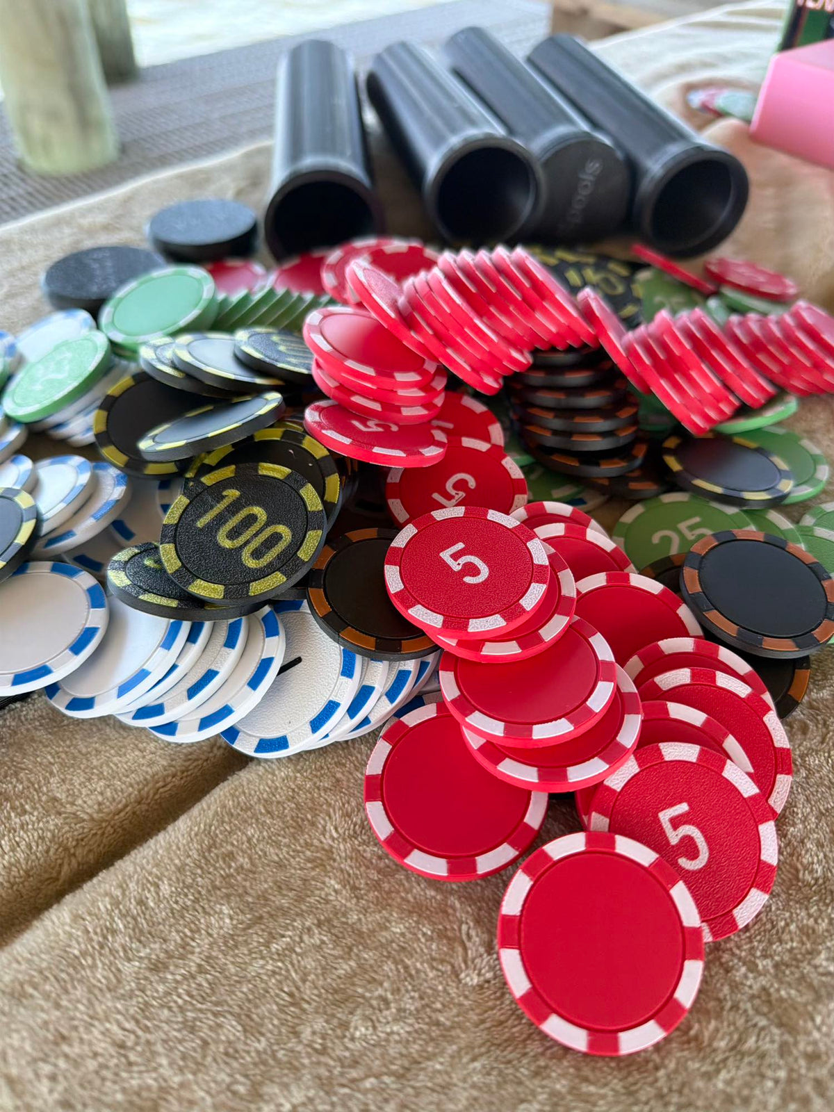 Spools lightweight poker chips spread out on a table showing color variety and textured surface.
