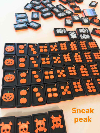 A set of black rectangular counting tiles with orange Halloween-themed designs, including pumpkins, skulls, and faces, arranged on a light surface. The text 'Sneak peak' appears in the bottom right corner.