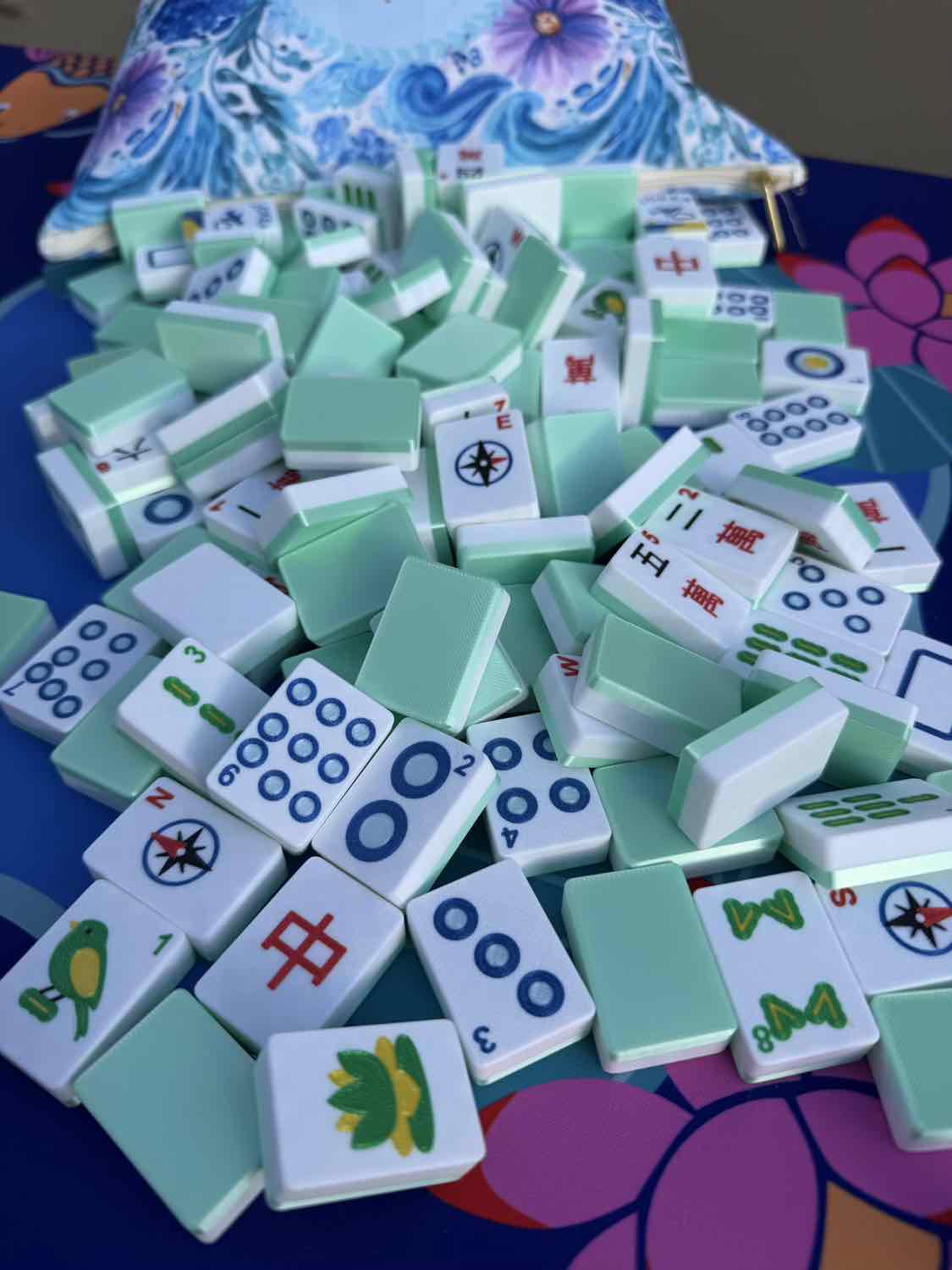 Stack of green and white麻将 tiles on a colorful surface