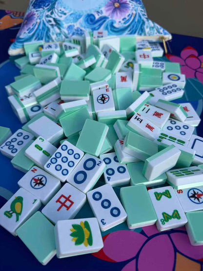 Stack of green and white麻将 tiles on a colorful surface