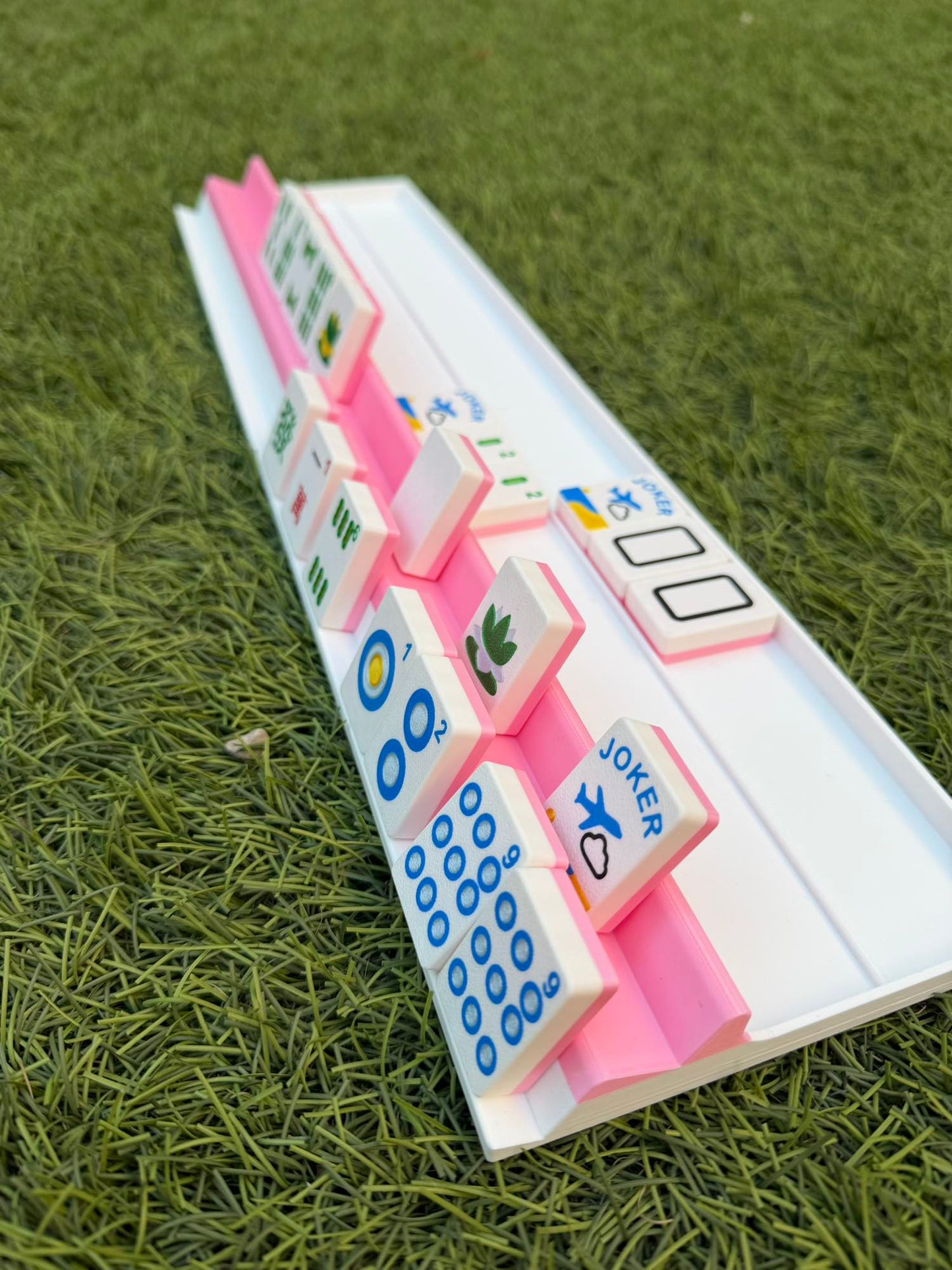 Set of colorful Mahjong tiles on a green grass background