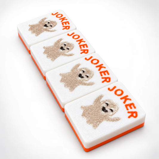 Four Spools mahjong joker tiles with flat sparkly ghosts and orange JOKER lettering, white tile faces with orange backs