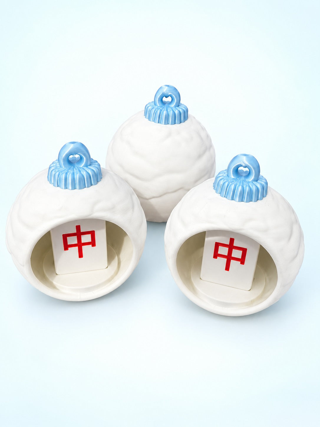 Front view of white mahjong bauble ornaments by Spools with red dragon tiles inside and pale blue caps