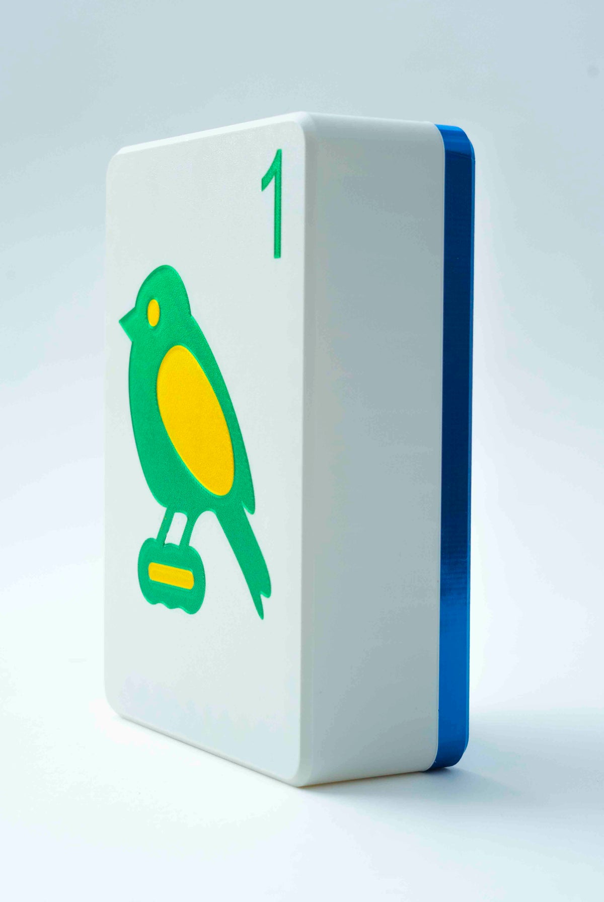 Spools mega mahjong tile display case with a royal blue back and white face showing the 1 bam bird, on a light gray background