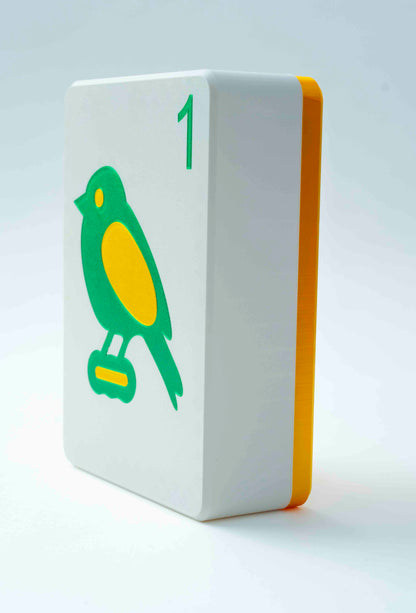 Spools mega mahjong tile display case with a gold back and white face showing the 1 bam bird, angled on a light gray background