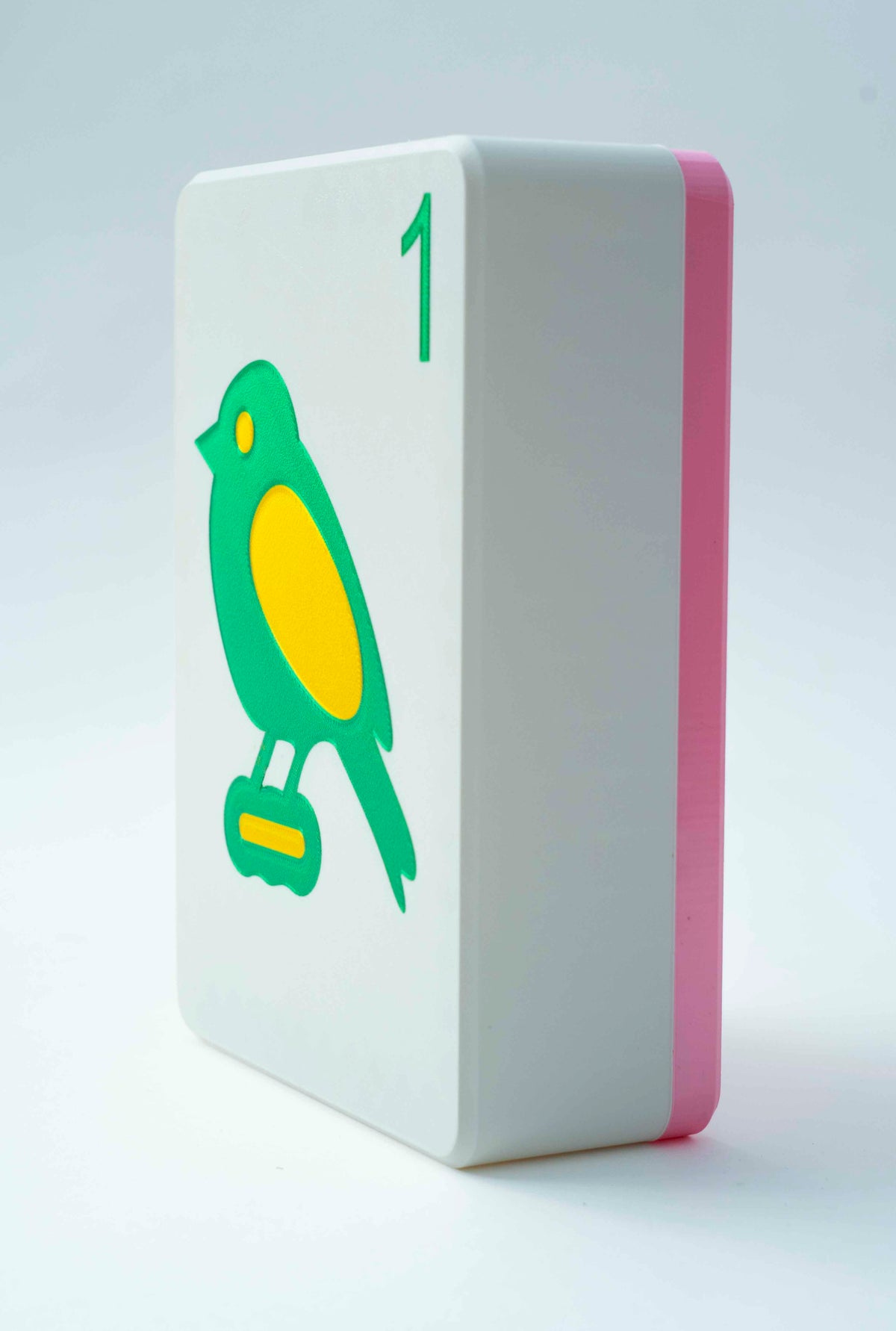 Spools mega mahjong tile display case with a pink back and white face showing the 1 bam bird, on a light gray background